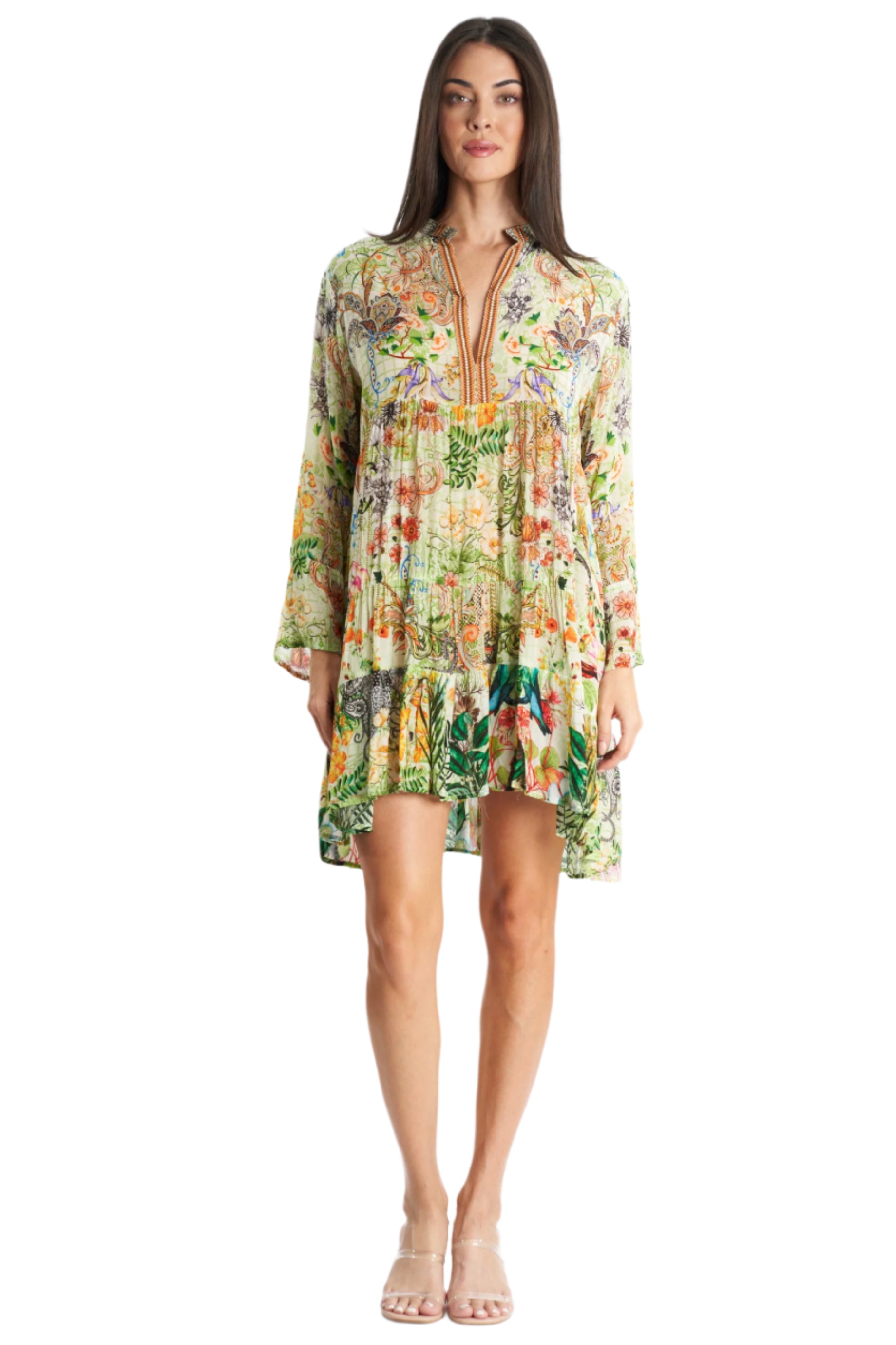 A woman in the La Moda Clothing Mini Dress for beach resort & cruise, featuring a loose fit, floral pattern, short hemline, and V-neckline, stands forward with long hair and clear heeled sandals—ideal for any vacation wardrobe.