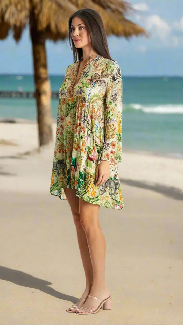 A woman wears the La Moda Clothing Mini Dress for beach resort & cruise with sandals on a sunny, sandy beach—an ideal choice for vacation style.