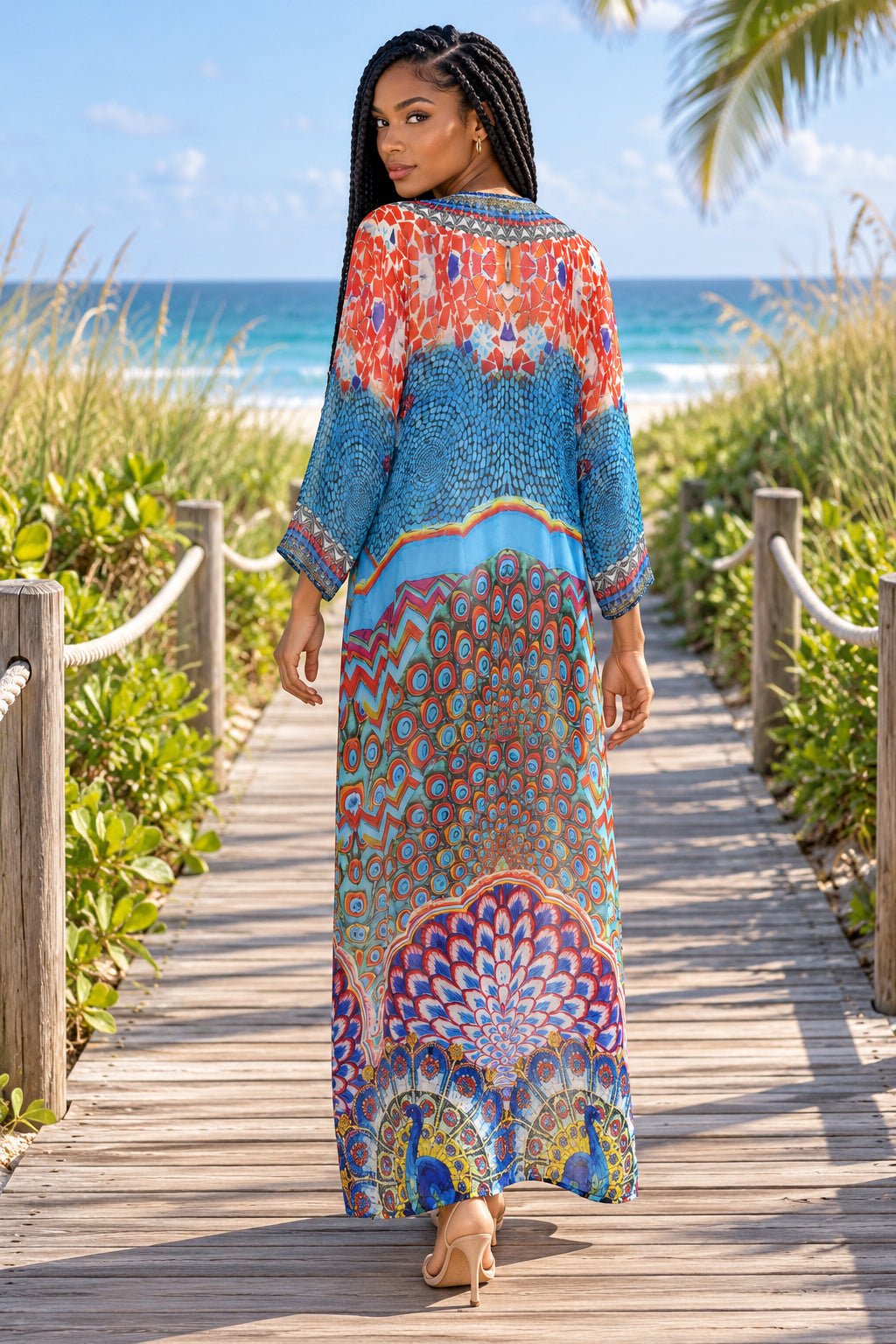 Back view of long kimono with peacock feather print on a beach boardwalk